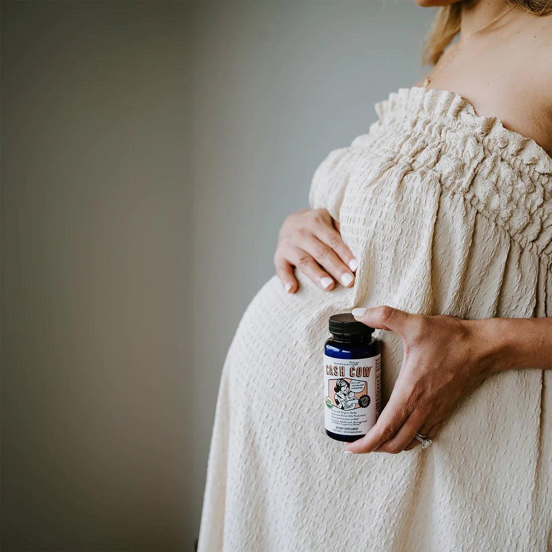 pregnant woman posing with cash cow supplement